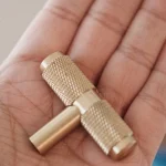 A brass drum key held in an open palm