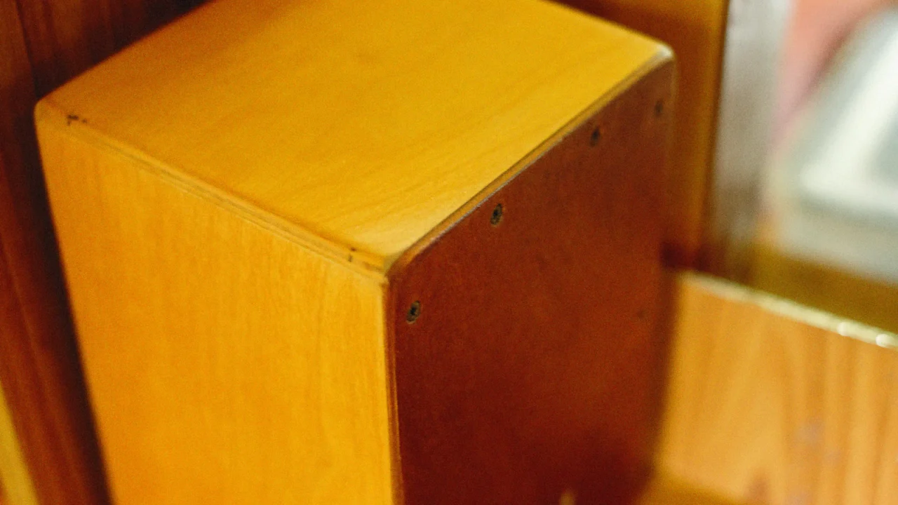 Close-up of a wooden cajon showing its screwed-on front plate