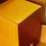 Close-up of a wooden cajon showing its screwed-on front plate
