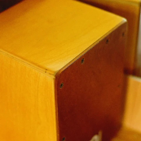 Close-up of a wooden cajon showing its screwed-on front plate