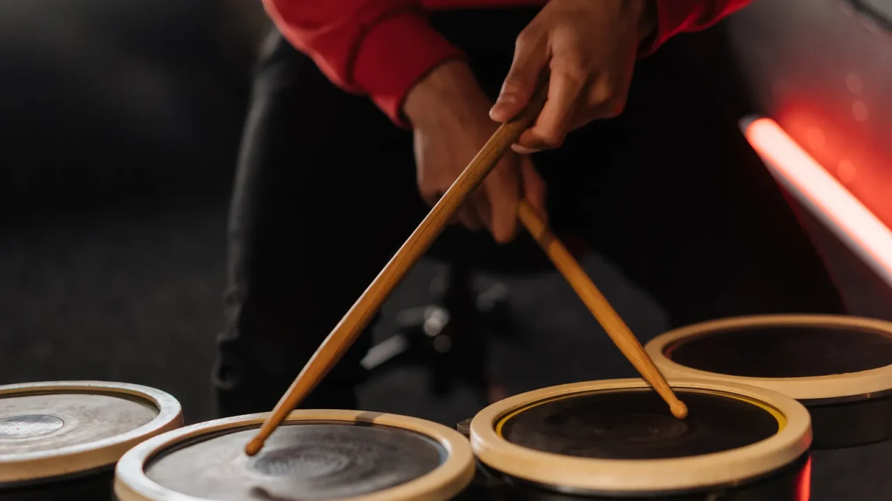 A drummer playing small drums with wooden sticks