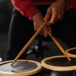 A drummer playing small drums with wooden sticks