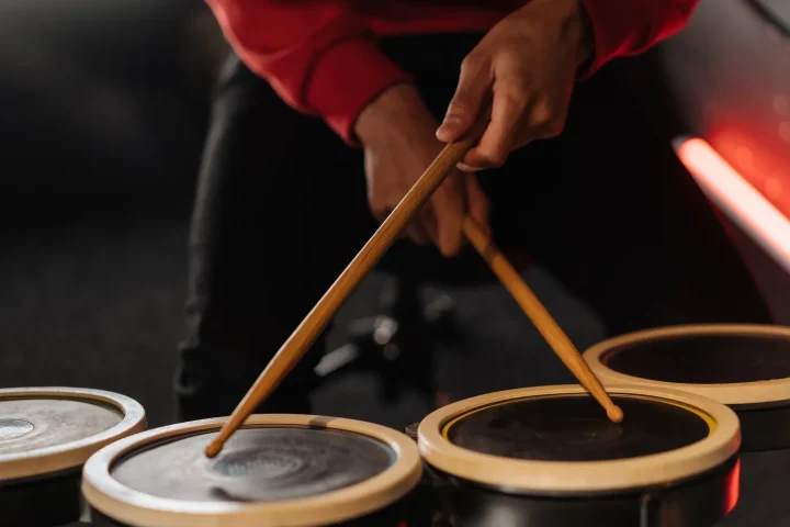A drummer playing small drums with wooden sticks