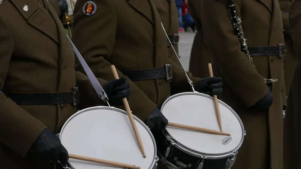 Uniformed marching drummers playing snare drums with gloved hands