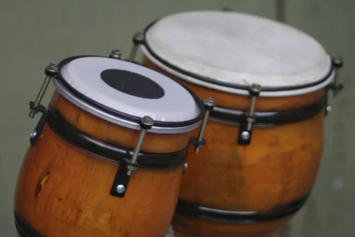 A pair of wooden bongo drums with natural heads