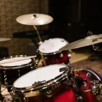 A red drum kit set up in a rehearsal studio